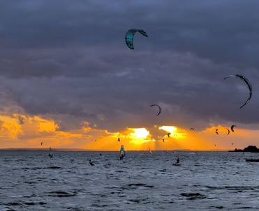 Dziesiątki latawc&oacute;w nad wodą i pomarańczowe słońce tworzą widowiskową scenę sport&oacute;w wodnych. Jastarnia jest jednym z najpopularniejszych miejsc do kitesurfingu na P&oacute;łwyspie Helskim.